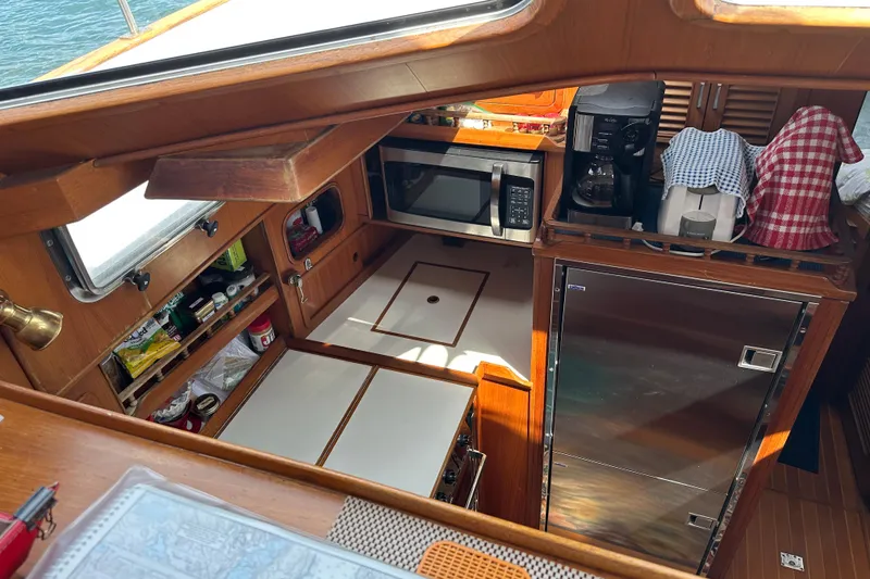 Slide: The Image of 1987 Albin North Sea Trawler galley with microwave, coffee maker, and storage cabinets. - 64