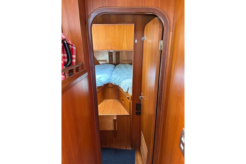 Slide: The Image of 1987 Albin North Sea Trawler cabin interior with wooden finish and cozy bedding. - 68