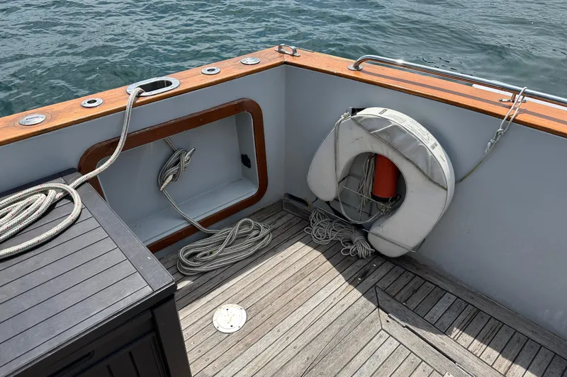 Slide: The Image of 1987 Albin North Sea Trawler deck with ropes and life preserver by the water. - 7