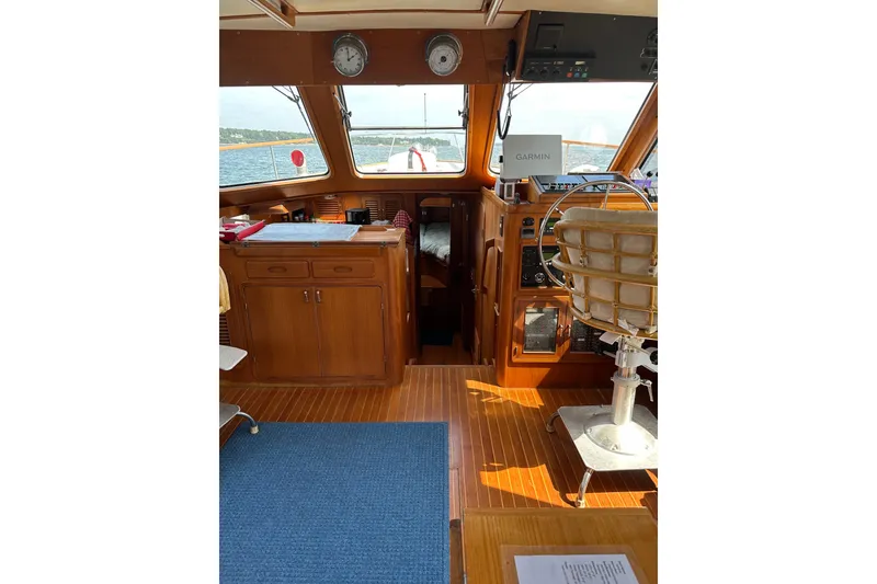 Slide: The Image of 1987 Albin North Sea Trawler interior with wooden helm, navigation equipment, and ocean view. - 77