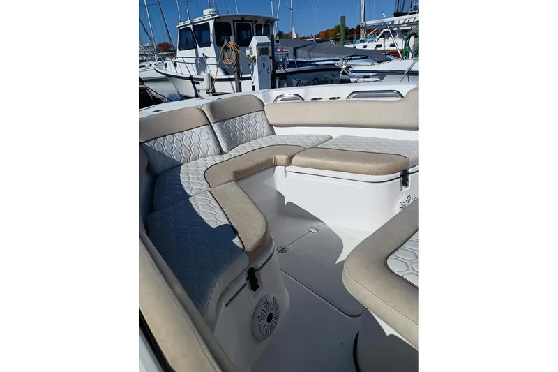 Slide: The Image of 2021 Sea Fox 228 Commander boat interior with cushioned seating in a marina setting. - 14