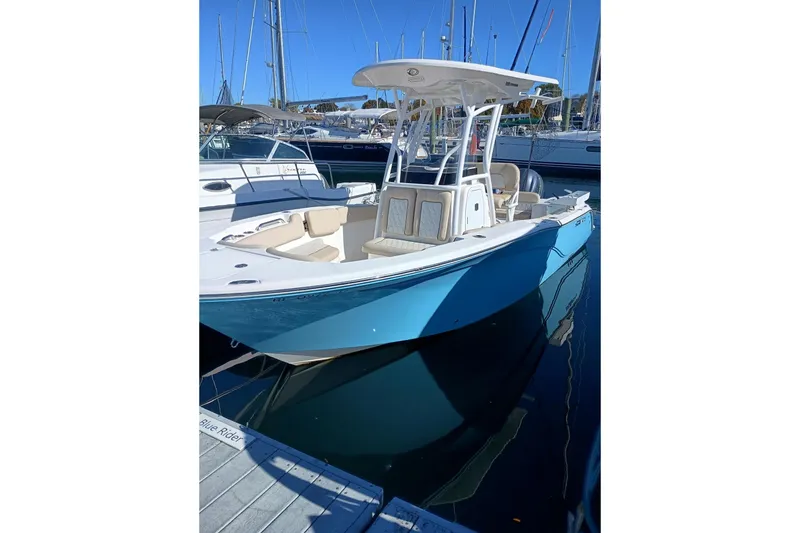 Slide: The Image of 2021 Sea Fox 228 Commander boat docked in marina, featuring sleek design and blue hull. - 2