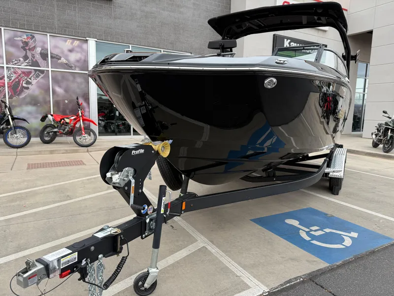 Slide: The Image of 2025 Yamaha Boats 255XD on trailer in parking lot, near motorcycles. - 11