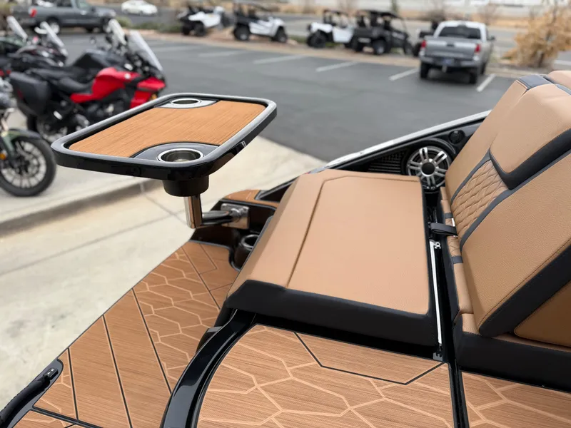 Slide: The Image of 2025 Yamaha Boats 255XD interior with tan seating and a mounted table. - 17