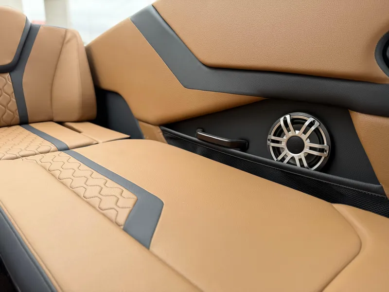 Slide: The Image of 2025 Yamaha Boats 255XD interior with tan and black upholstery, featuring a built-in speaker. - 37
