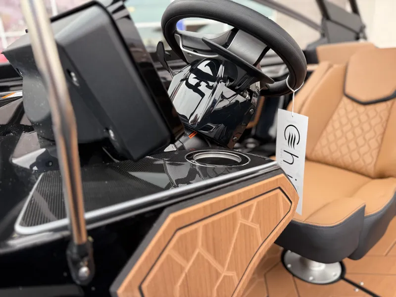 Slide: The Image of 2025 Yamaha Boats 255XD interior with steering wheel and tan seating. - 55