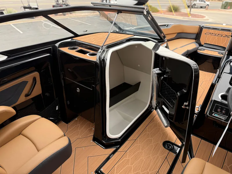 Slide: The Image of 2025 Yamaha Boats 255XD interior with open storage compartment and luxurious seating. - 57