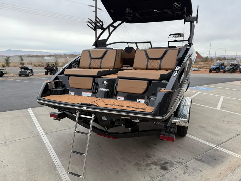 Slide: The Image of 2025 Yamaha Boats 255XD with tan seating and swim platform ladder. - 6