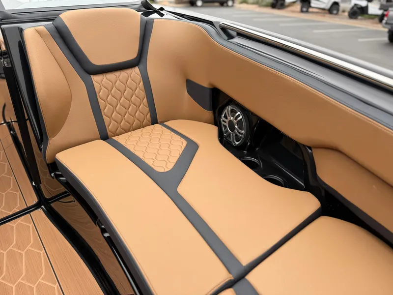 Slide: The Image of 2025 Yamaha Boats 255XD interior with tan and black seating, featuring stylish design and speaker system. - 67