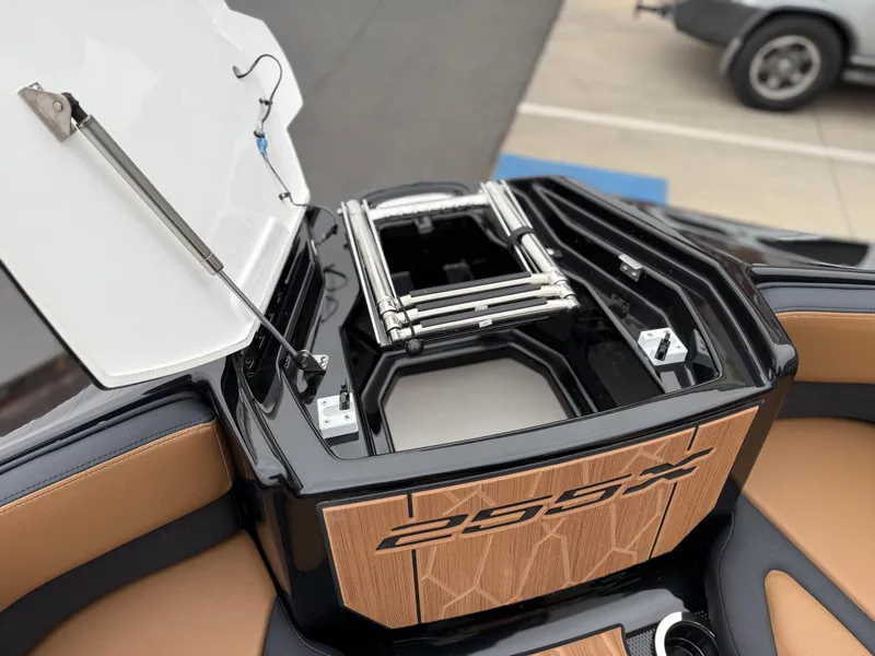 Slide: The Image of 2025 Yamaha Boats 255XD, open storage compartment with ladder, sleek design, tan and black interior. - 71