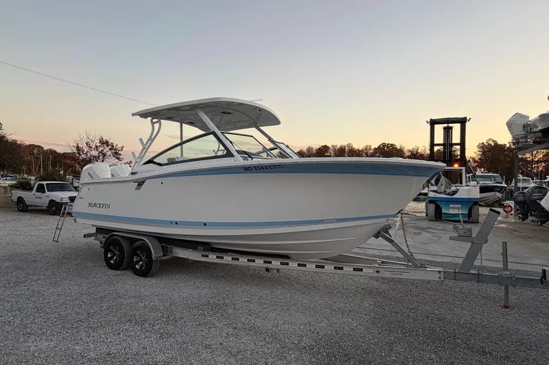 Slide: The Image of 2023 Blackfin 272 DC boat on trailer at sunset, parked in a marina. - 21