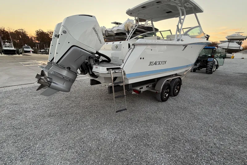 Slide: The Image of 2023 Blackfin 272 DC boat on trailer with dual outboard engines at marina. - 23