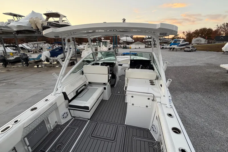 Slide: The Image of 2023 Blackfin 272 DC boat interior with seating and helm, docked at marina. - 27