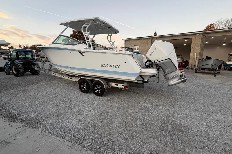 Slide: The Image of 2023 Blackfin 272 DC boat on trailer, parked outdoors near a building. - 28