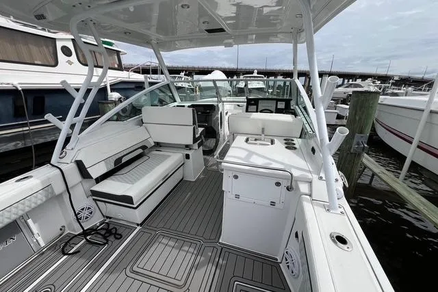 Slide: The Image of 2023 Blackfin 272 DC boat interior with seating and helm, docked at marina. - 7