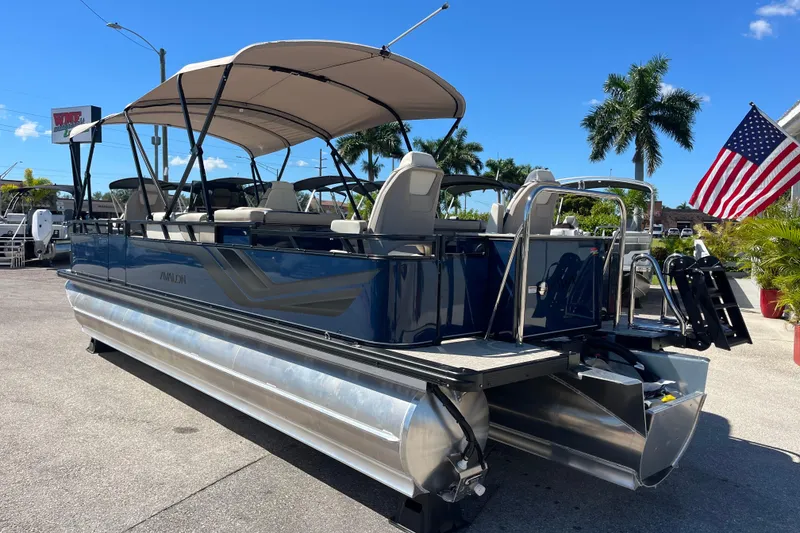 Slide: The Image of 2025 Avalon 2585 Venture 85 Tri Toon boat with center console, parked outdoors. - 7