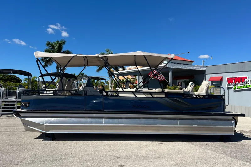 Slide: The Image of 2025 Avalon 2585 Venture 85 Tri Toon boat with canopy, parked outdoors. - 8