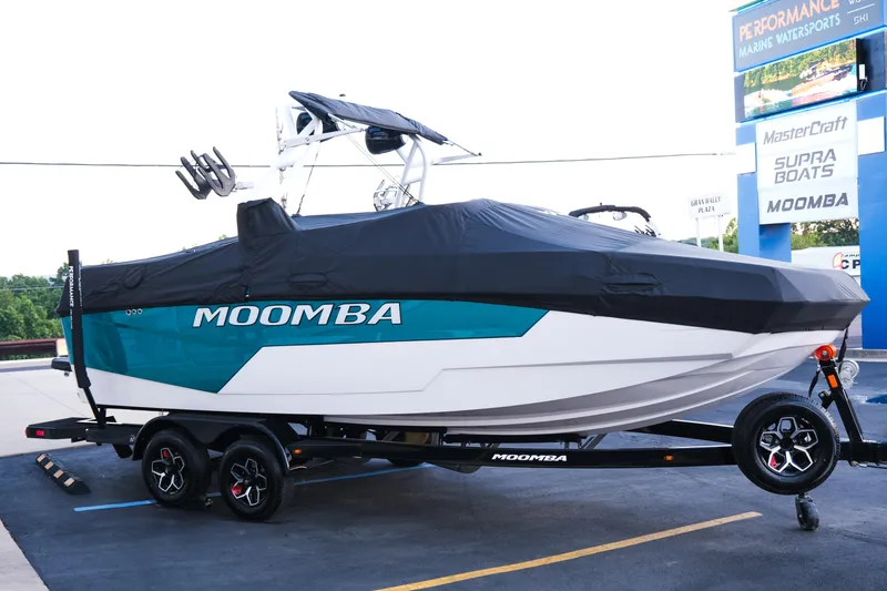 Slide: The Image of 2026 Moomba Max boat on trailer, covered, at a marine dealership. - 30