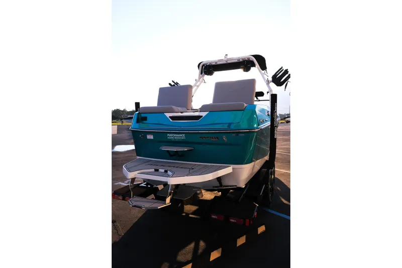 Slide: The Image of 2026 Moomba Max boat, teal color, rear view on trailer, outdoor setting. - 9