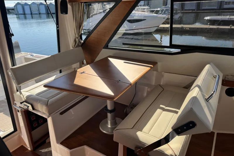 Slide: The Image of Interior of 2026 Cutwater C-288 CB boat with seating and table by the window. - 12