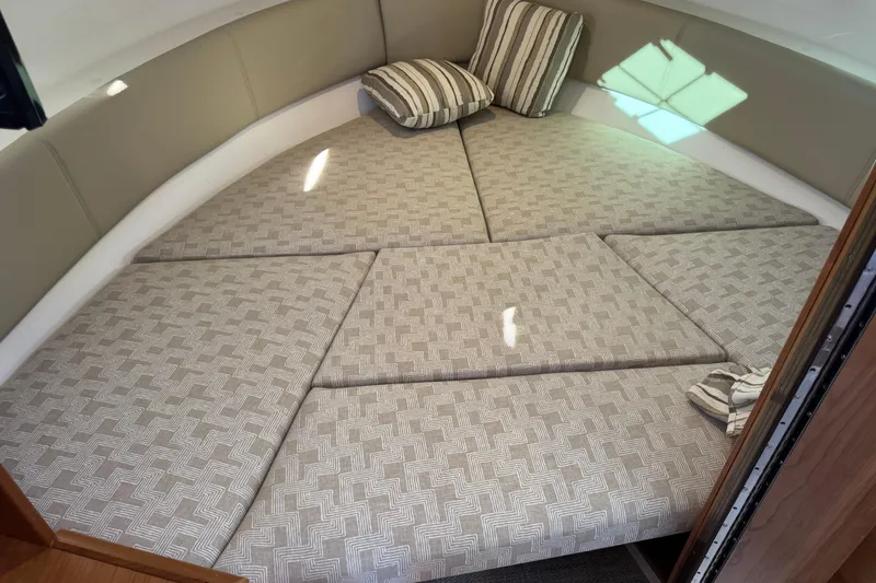 Slide: The Image of 2026 Cutwater C-288 CB cabin interior with patterned cushions and striped pillows. - 14