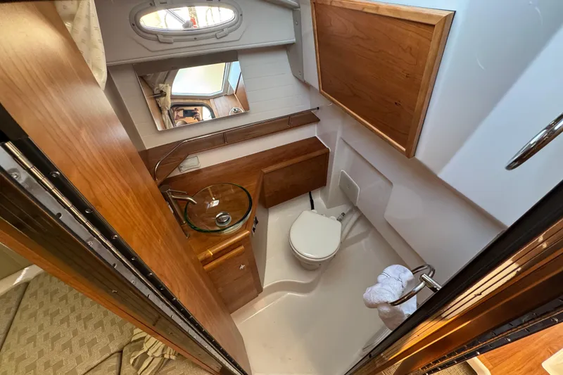 Slide: The Image of 2026 Cutwater C-288 CB boat bathroom with wooden cabinetry and glass sink. - 15