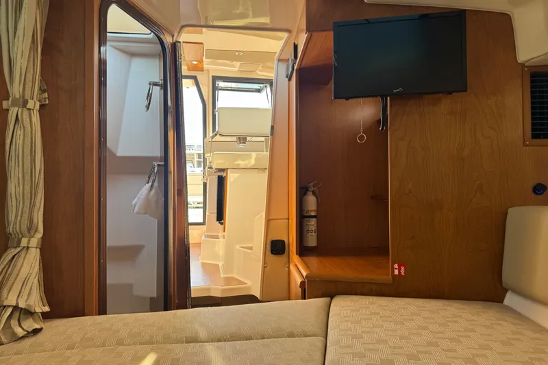 Slide: The Image of Interior of 2026 Cutwater C-288 CB boat with TV, fire extinguisher, and seating area. - 16