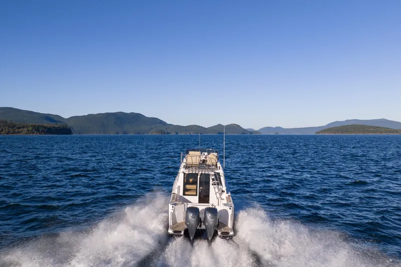 Slide: The Image of 2026 Cutwater C-288 CB cruising on open water with scenic mountain backdrop. - 2