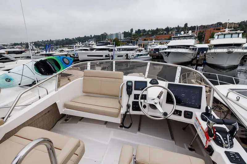 Slide: The Image of Manufacturer Provided Image: 2026 Cutwater C-288 CB boat cockpit with modern controls, docked among luxury yachts. - 3