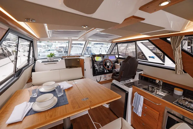 Slide: The Image of Manufacturer Provided Image: Luxurious interior of 2026 Cutwater C-288 CB yacht with dining area and helm station. - 5