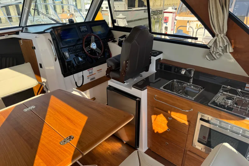 Slide: The Image of Interior of 2026 Cutwater C-288 CB boat with helm, kitchenette, and seating area. - 8