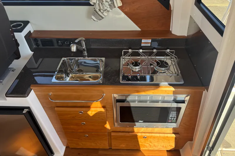 Slide: The Image of Compact kitchen in 2026 Cutwater C-288 CB boat with stove, sink, and microwave. - 9