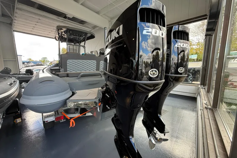 Slide: The Image of 2025 Highfield Sport 800 boat with dual Suzuki 200 outboard motors in showroom. - 19