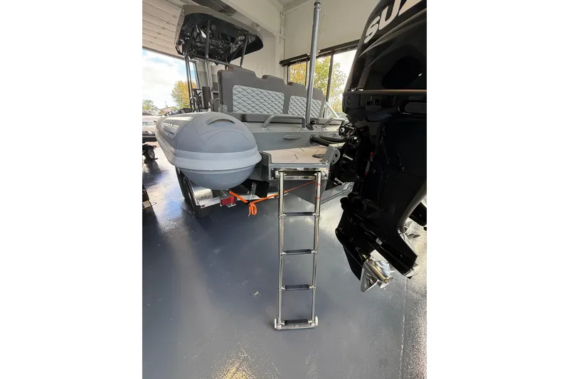 Slide: The Image of 2025 Highfield Sport 800 boat with ladder and outboard motor in showroom. - 20