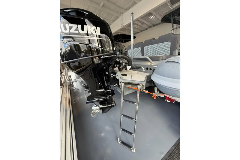 Slide: The Image of 2025 Highfield Sport 800 boat with Suzuki outboard motor and ladder, displayed indoors. - 21