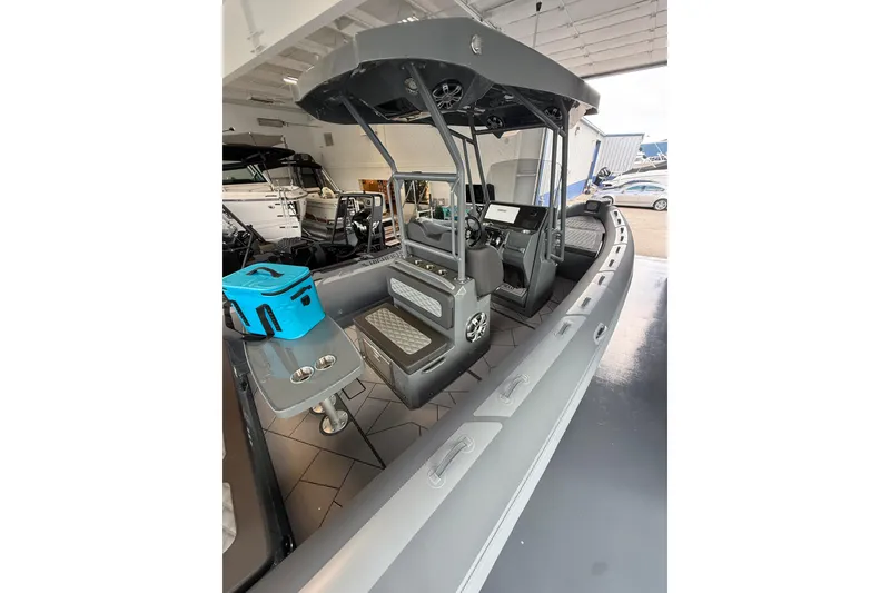 Slide: The Image of 2025 Highfield Sport 800 boat interior with seating and console, displayed indoors. - 7