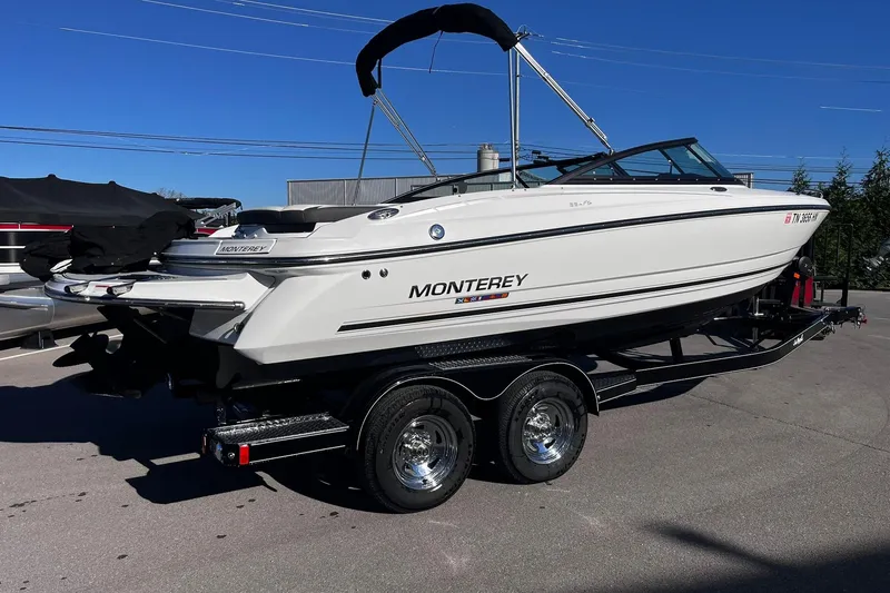 Slide: The Image of 2022 Monterey 224FS boat on trailer, parked outdoors under clear blue sky. - 2