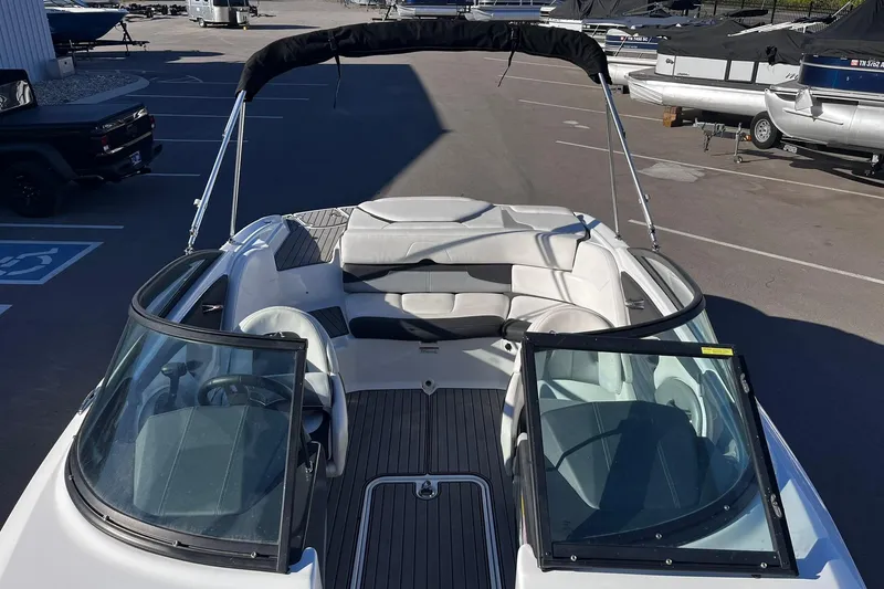 Slide: The Image of 2022 Monterey 224FS boat with open deck and seating, parked in a marina. - 6
