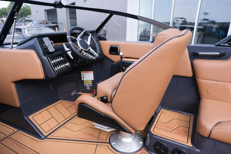 Slide: The Image of 2026 Moomba Tykon boat interior with tan leather seats and modern steering console. - 19