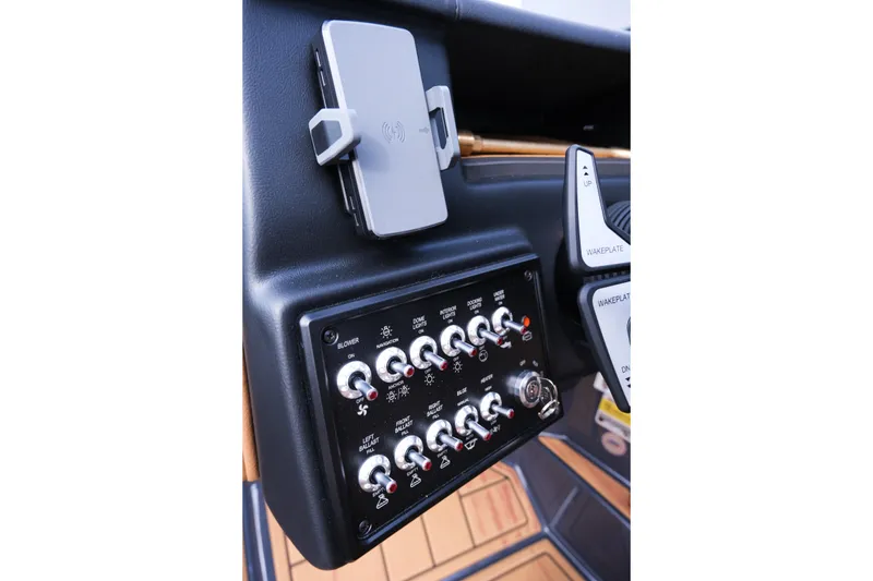 Slide: The Image of Control panel of 2026 Moomba Tykon boat with switches and phone holder. - 25