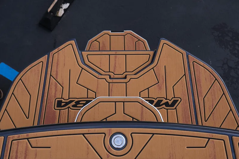Slide: The Image of 2026 Moomba Tykon boat deck with wood finish and logo detailing. - 35