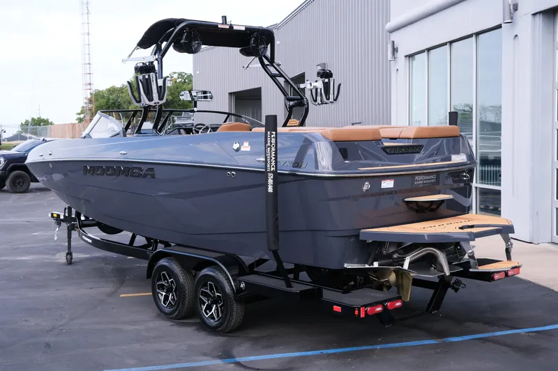 Slide: The Image of 2026 Moomba Tykon boat on trailer, parked outside a modern building. - 4