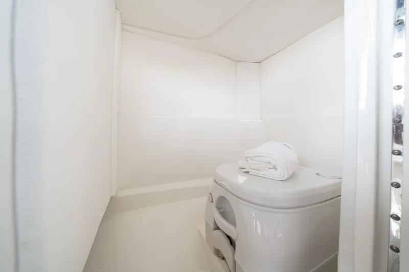 Slide: The Image of Manufacturer Provided Image: 2024 Sea Ray SPX 230 boat interior bathroom with white walls and compact toilet. - 25