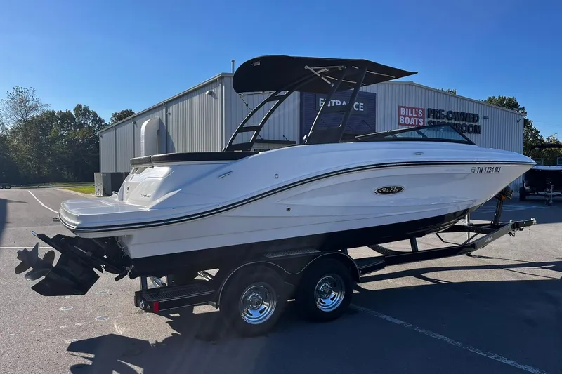 Slide: The Image of 2024 Sea Ray SPX 230 boat on trailer, parked outside showroom under clear sky. - 3