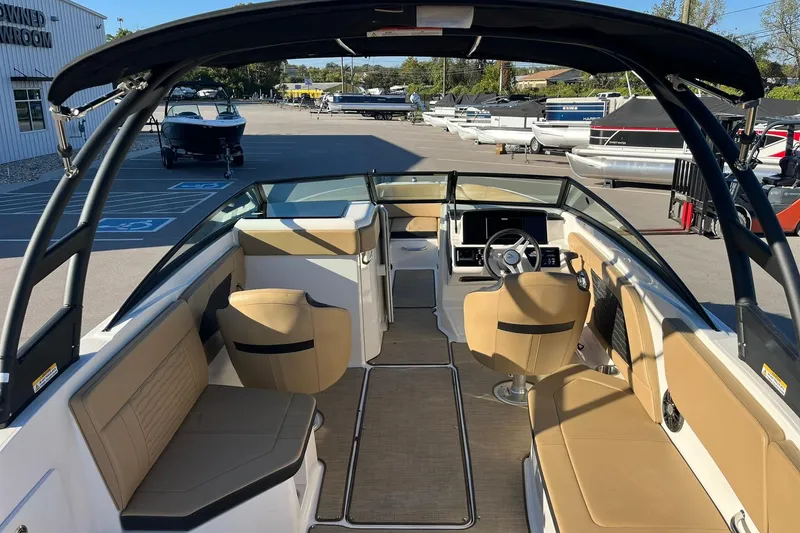 Slide: The Image of 2024 Sea Ray SPX 230 boat interior with tan seating and modern dashboard. - 5