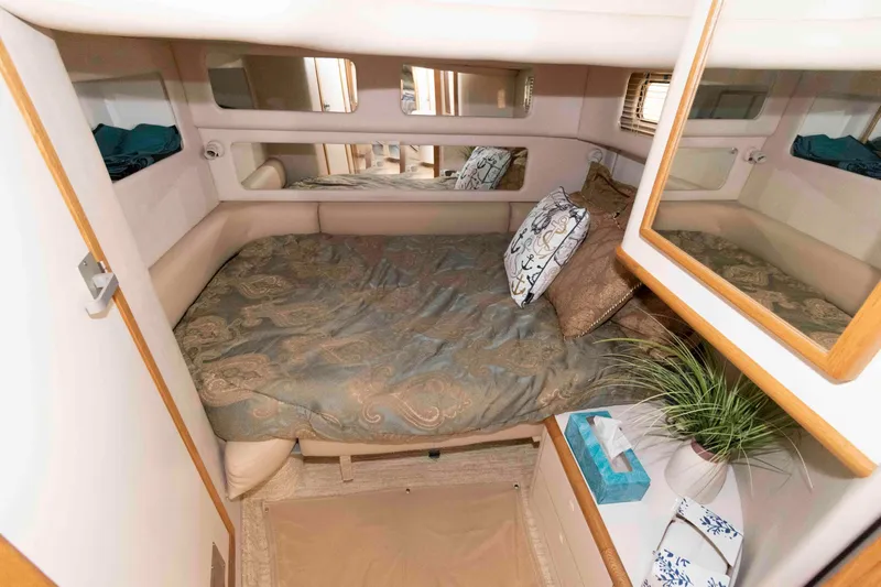 Slide: The Image of Cozy cabin interior of 1995 Sea Ray 440 Sundancer with bed and decor. - 13