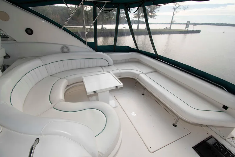 Slide: The Image of Luxurious 1995 Sea Ray 440 Sundancer yacht interior with white seating and scenic water view. - 2