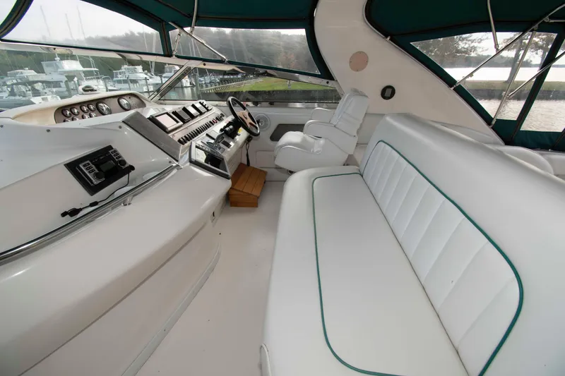Slide: The Image of Interior of 1995 Sea Ray 440 Sundancer yacht with white seating and control panel. - 4