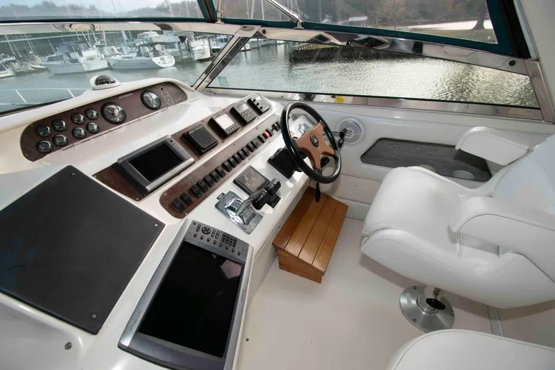 Slide: The Image of Cockpit of 1995 Sea Ray 440 Sundancer with steering wheel, controls, and navigation equipment. - 5