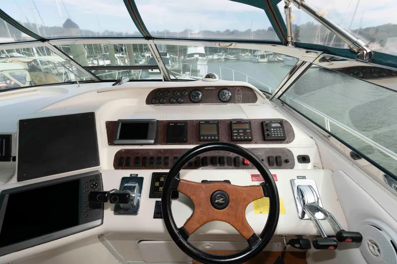 Slide: The Image of Cockpit of 1995 Sea Ray 440 Sundancer yacht with steering wheel and navigation controls. - 6